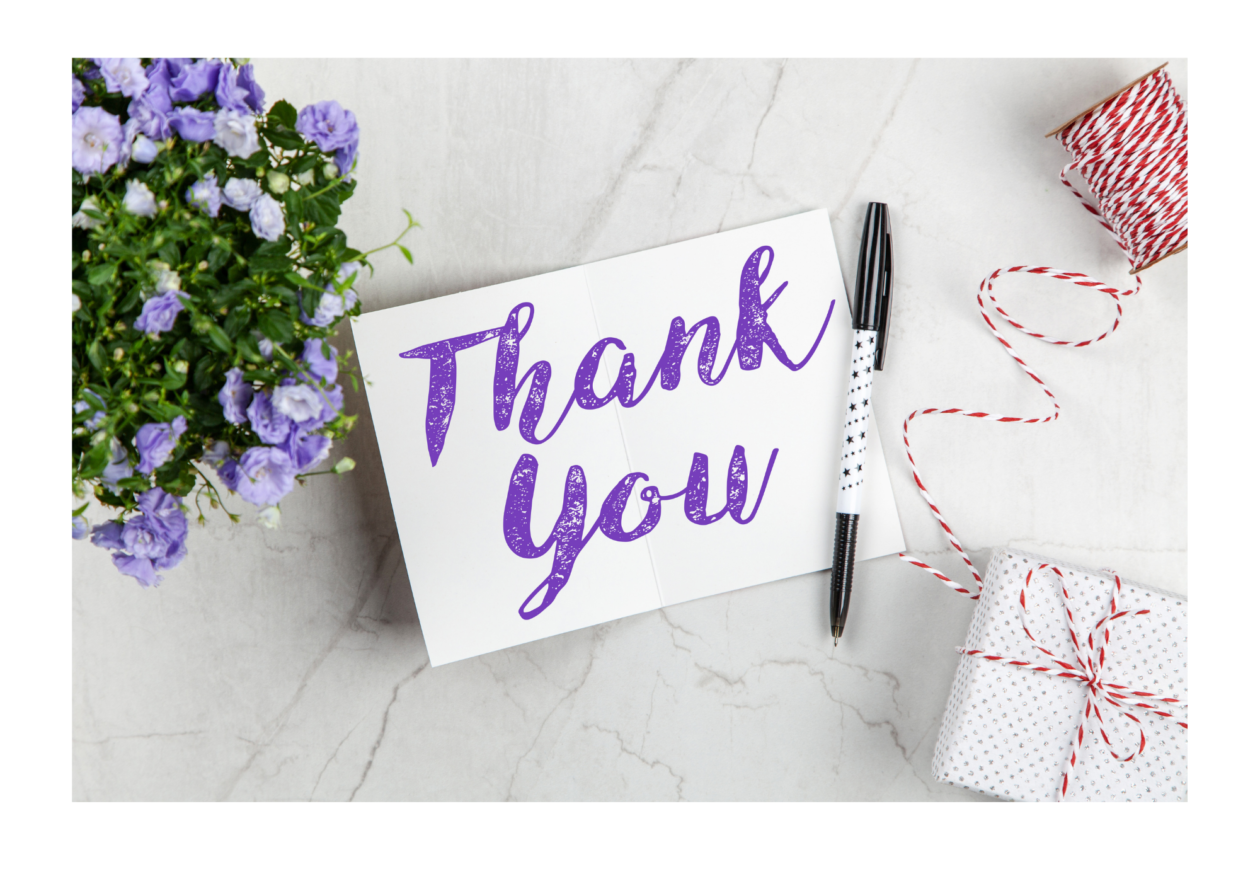 a note saying thank you with a pen and some purple flowers