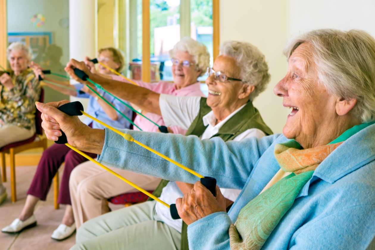 a group of elderly people sitting together smiling and laughin