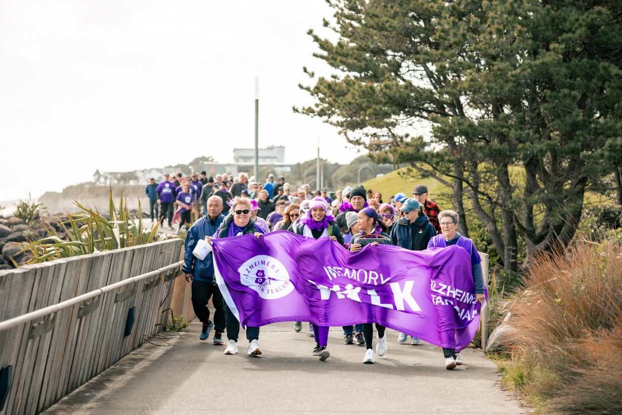 Group of walkers carrying a purple banner down the walkway