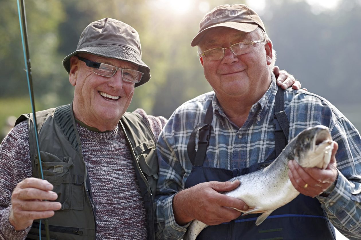 Two fishermen holding a fish.