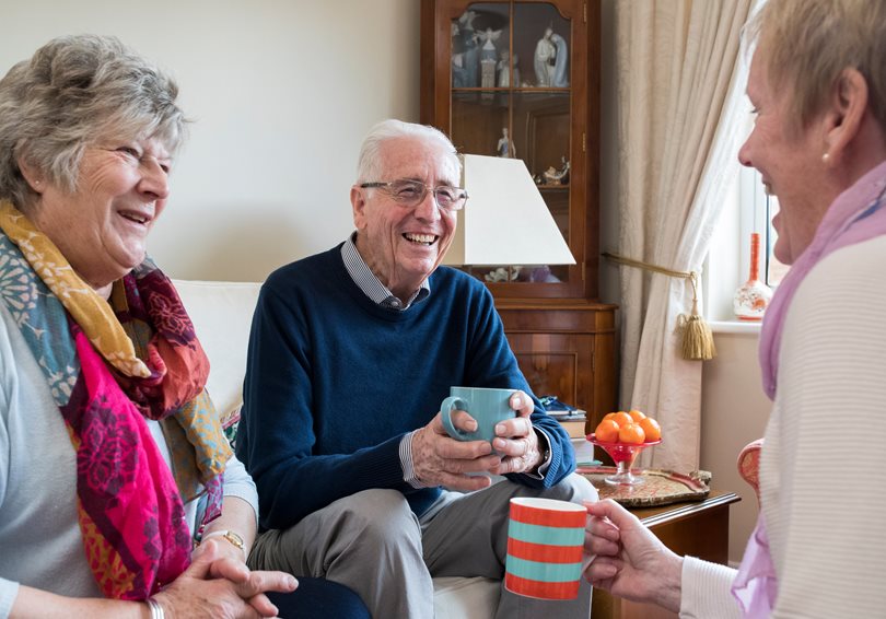 Three people drinking tea and laughing together