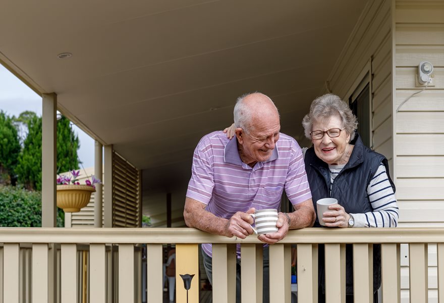 Couple on their front porch together drinking tea