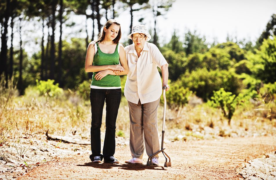 A girl helping a senior woman walk