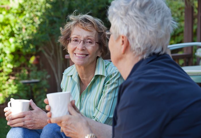 Two women smiling and drinking tea