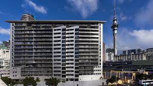 Outside of a hotel with Sky Tower in background