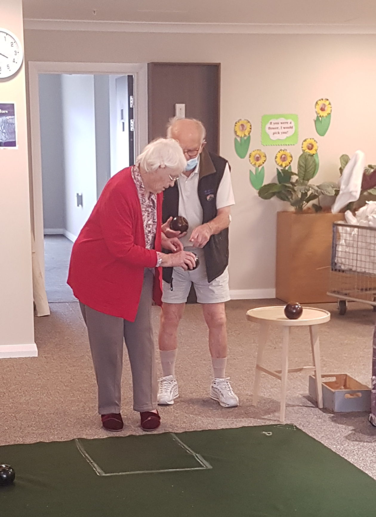 Two people playing indoor bowls